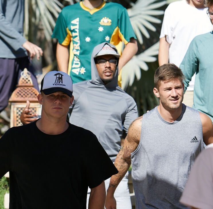 A group of men are standing together and one of them is wearing an australia shirt