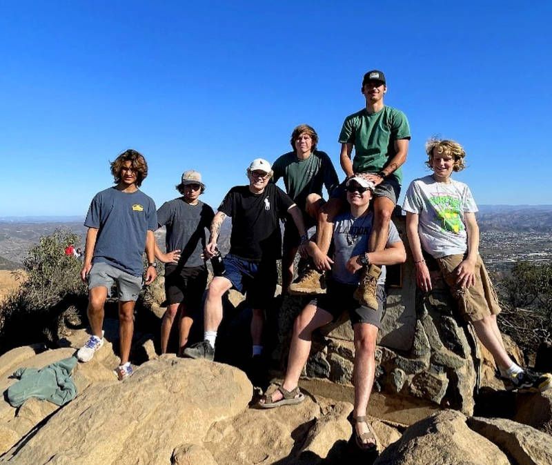 A group of people posing for a picture on top of a mountain