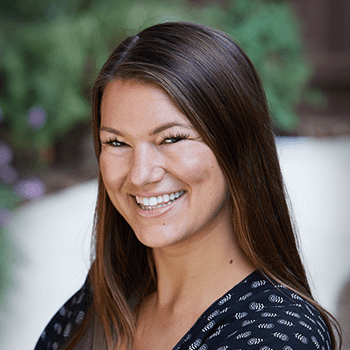 A woman with long hair is smiling for the camera.