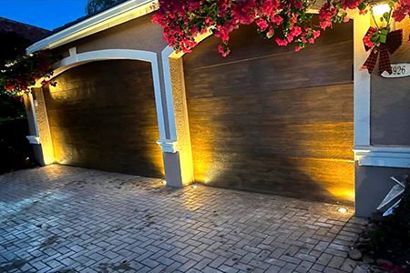 A couple of garage doors are lit up at night.
