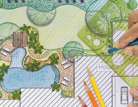 A person is drawing a landscape with a ruler and pencils