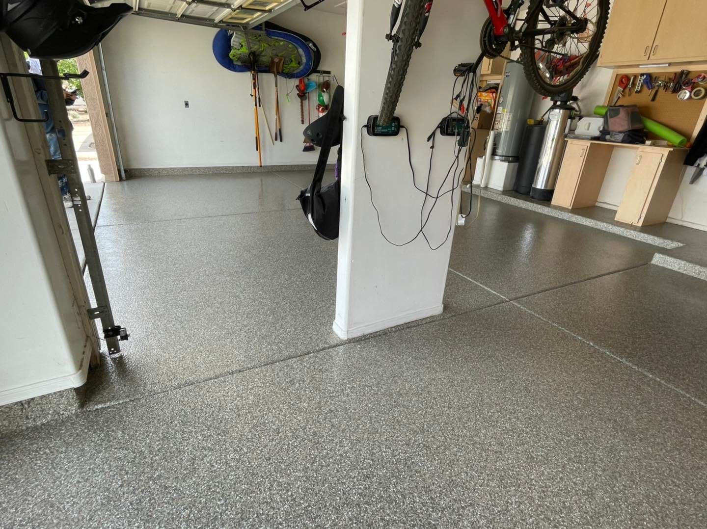 A bicycle is hanging on a wall in a garage.