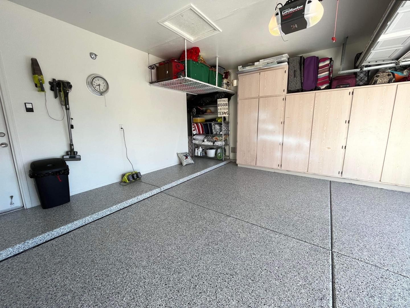 A garage with a lot of storage space and a vacuum cleaner hanging from the ceiling.