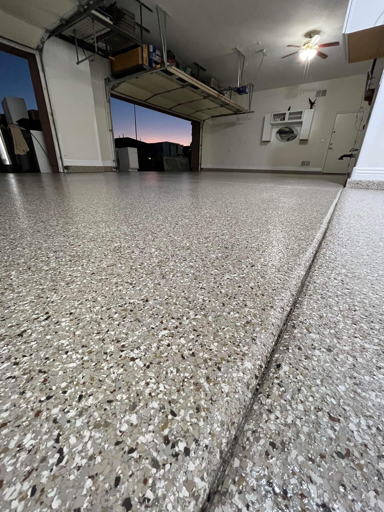 A close up of a garage floor with a ceiling fan.