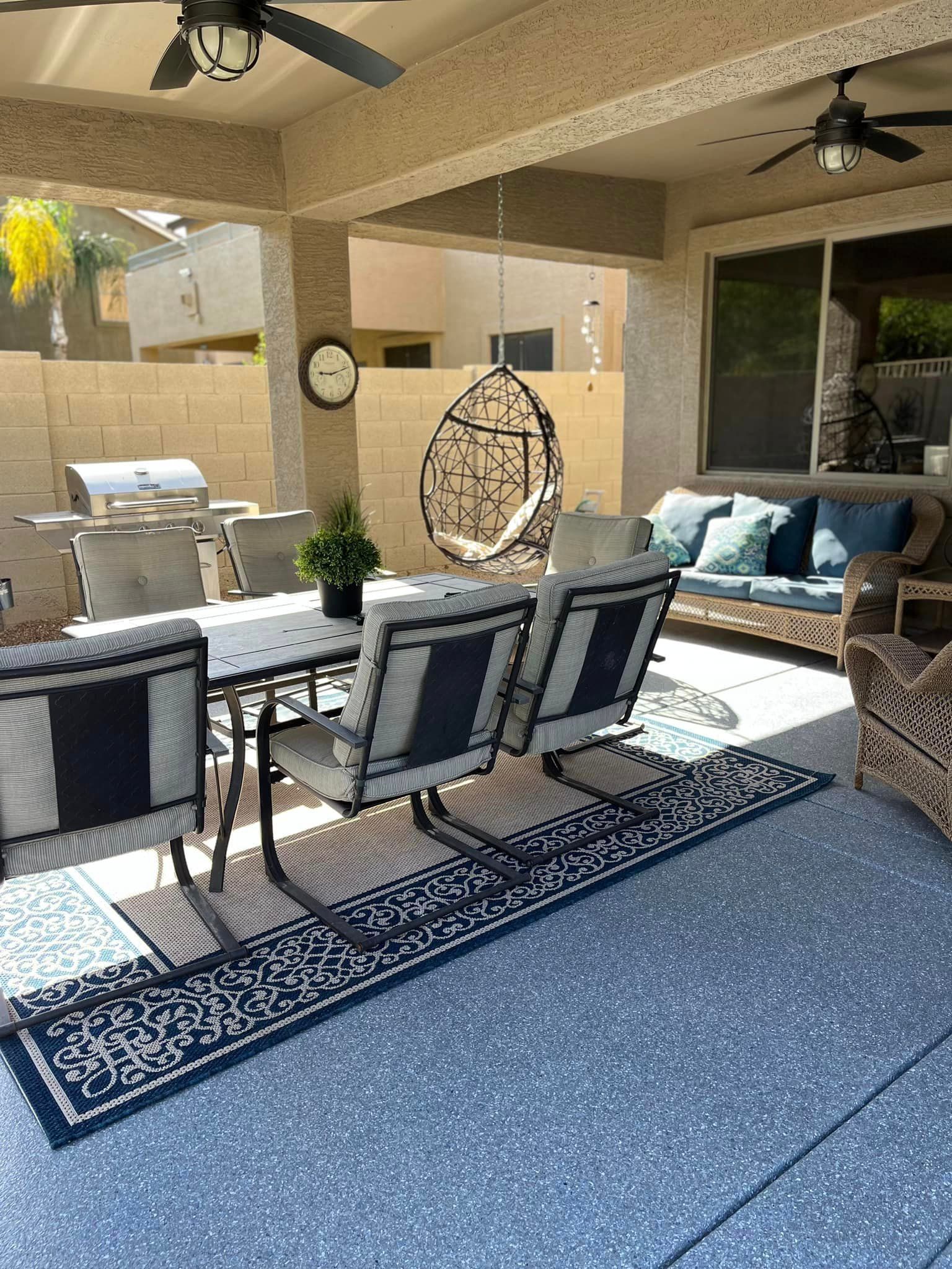 A patio with a table and chairs and a ceiling fan.
