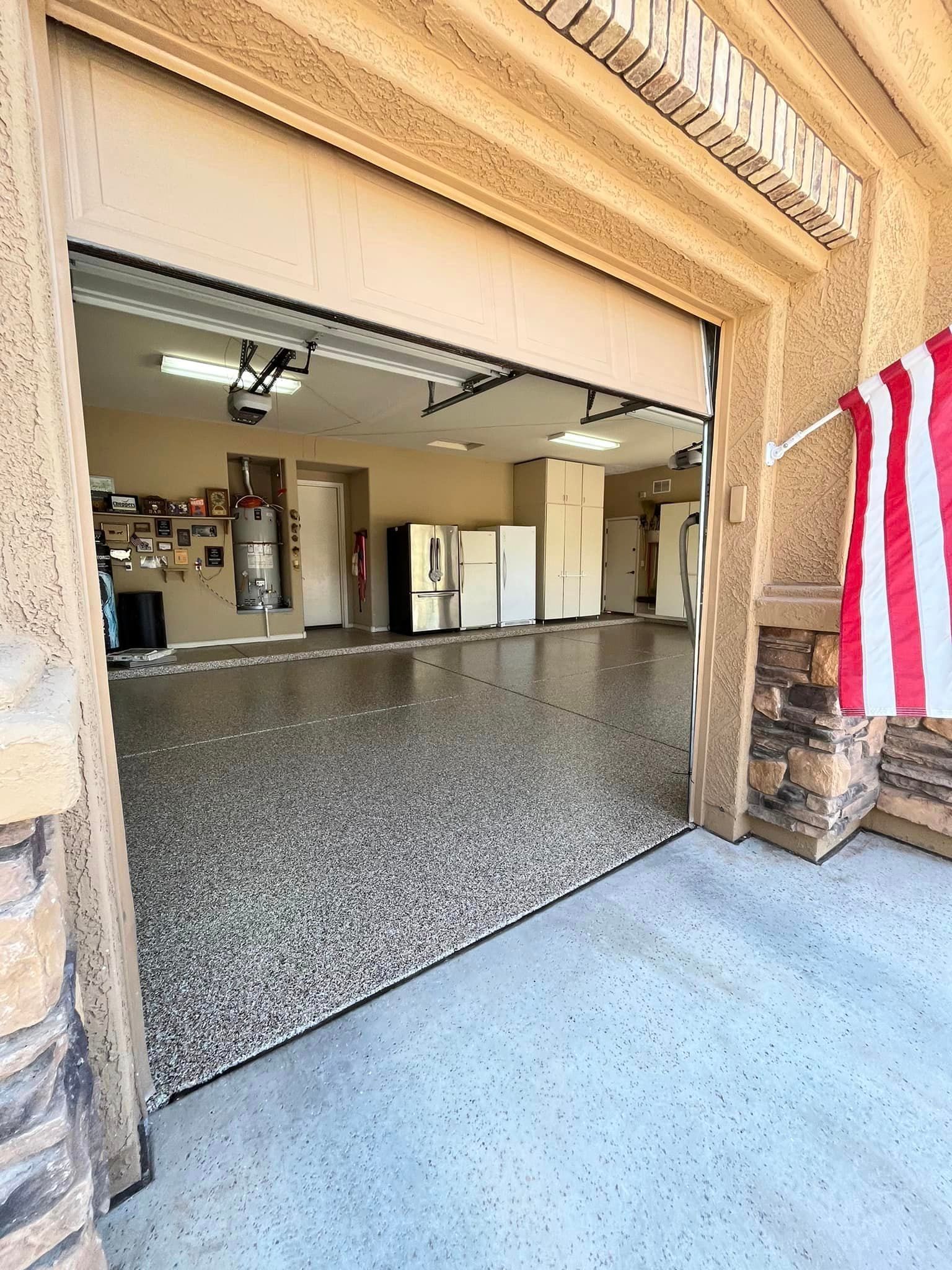 A garage with a garage door open and an american flag hanging from it.
