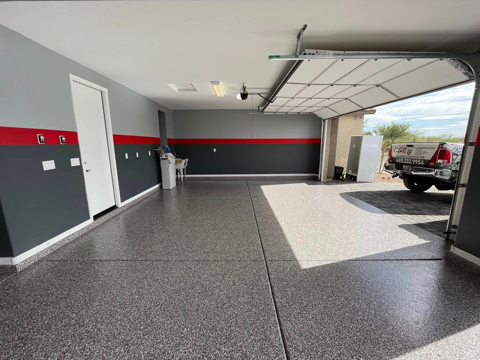 A garage with a truck parked in it and a garage door open.