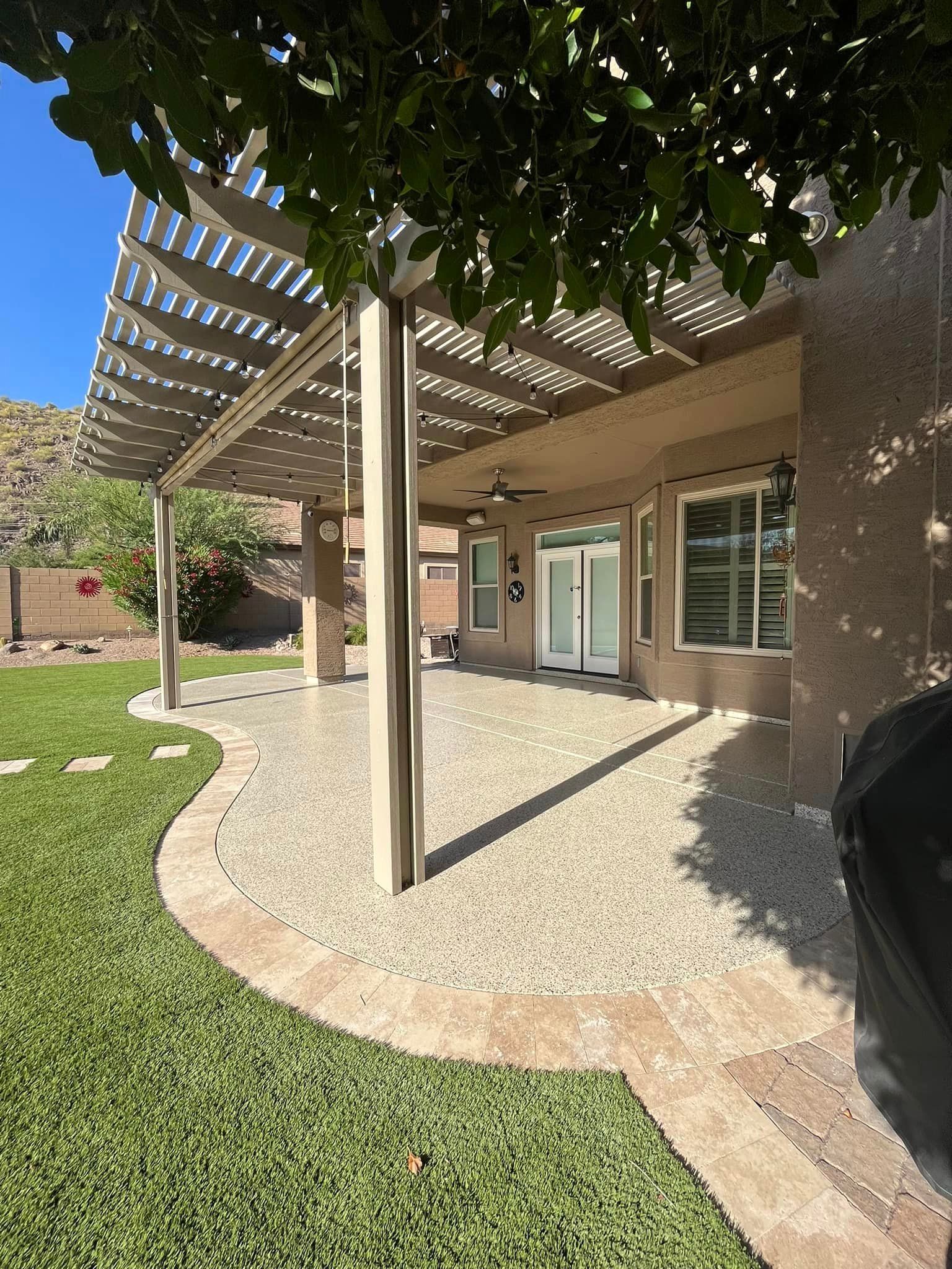 A patio with a pergola and a sliding glass door