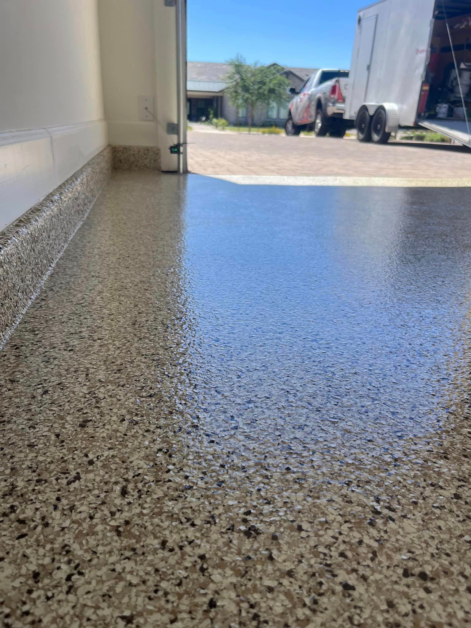 A truck is parked in a garage next to a trailer.