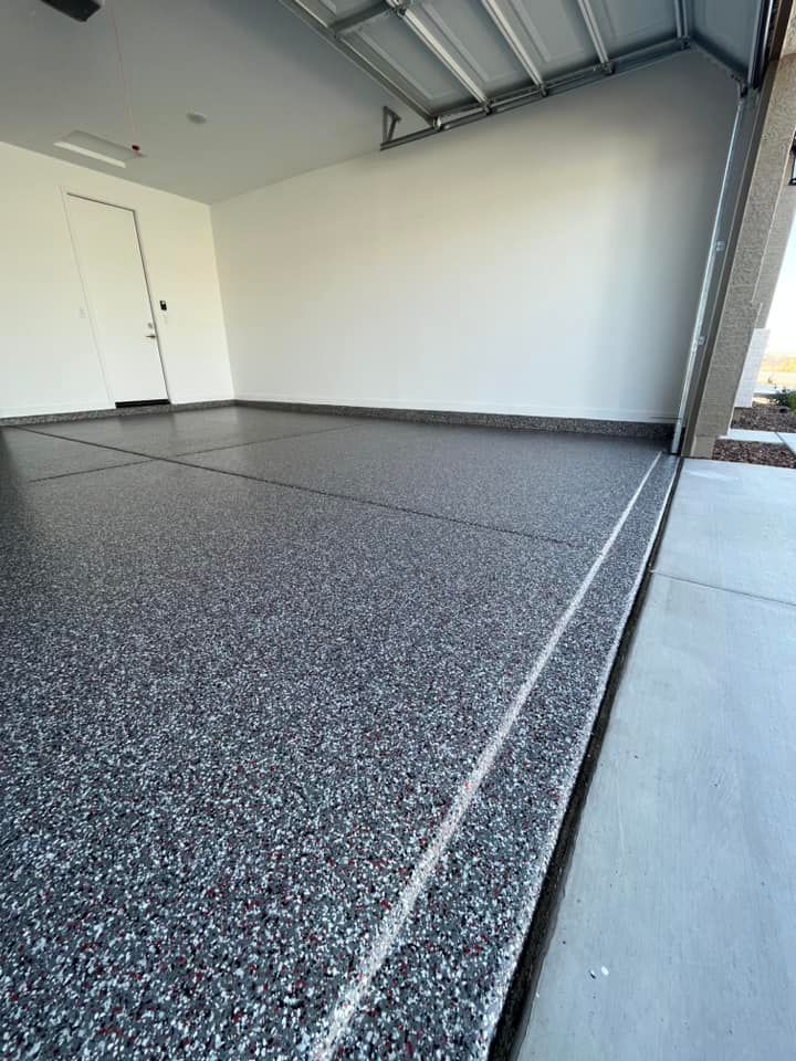 A garage with a gray floor and a white door.