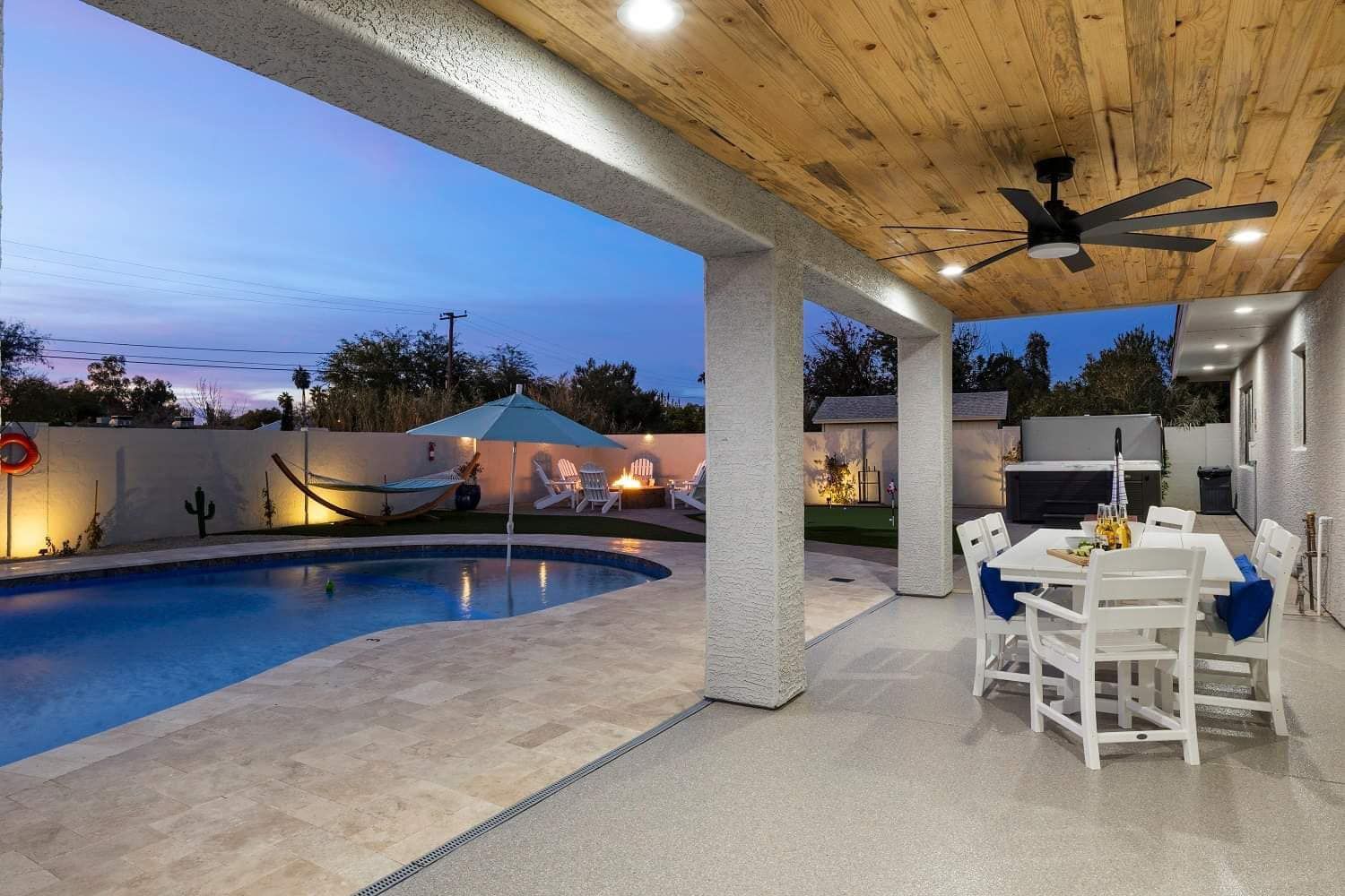 A patio with a table and chairs and a swimming pool