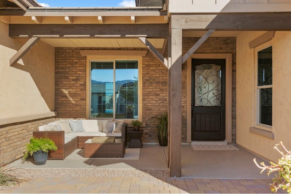 A porch with a couch and a table in front of a house.