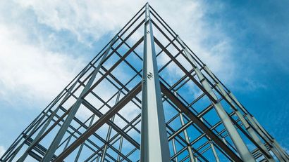 Looking Up At A Building Under Construction With A Blue Sky In The Background