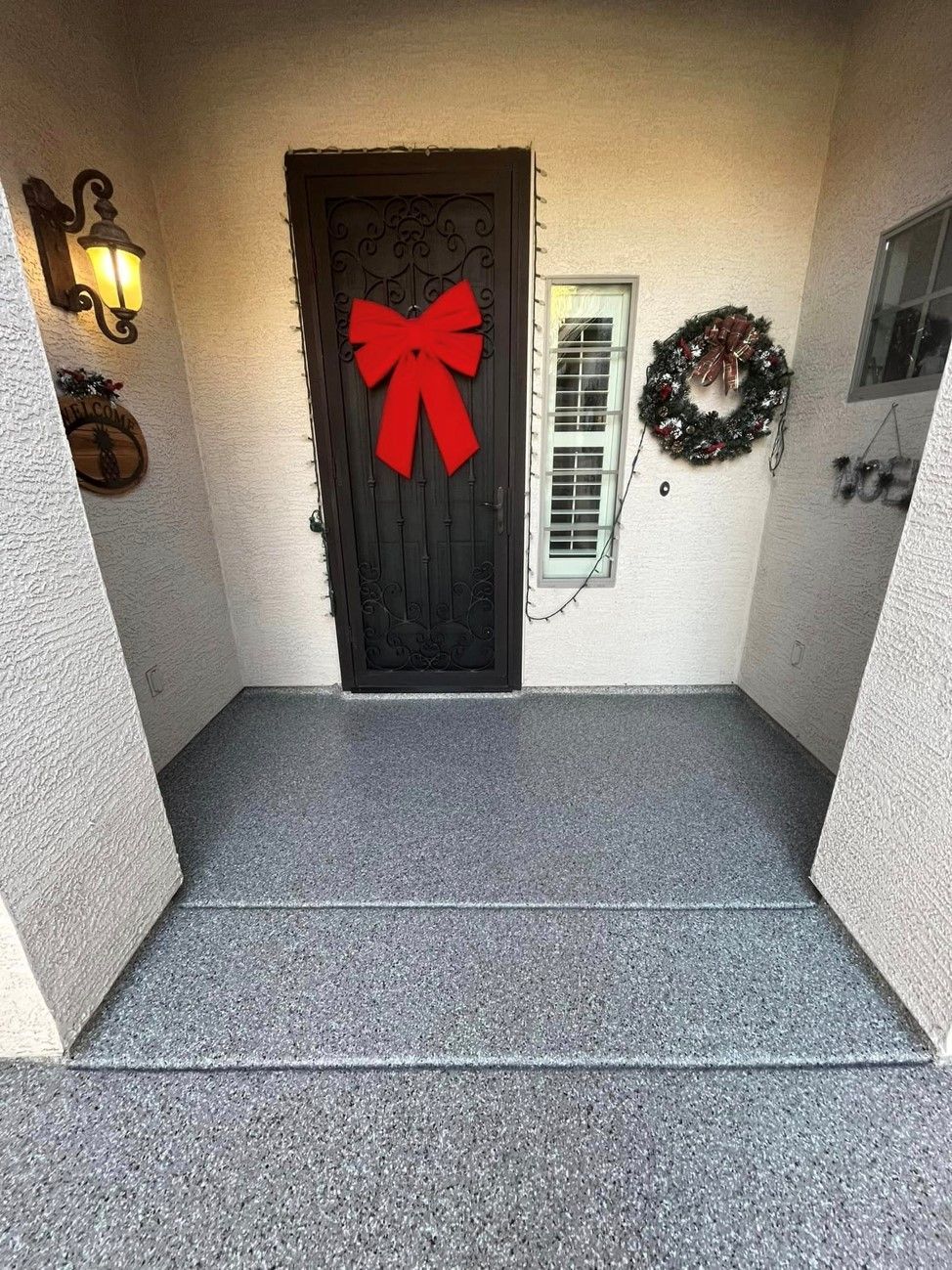 The front door of a house with a red bow on it.