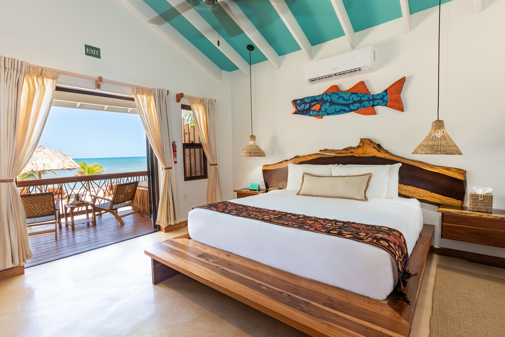 A bedroom with a large bed and a fish on the wall