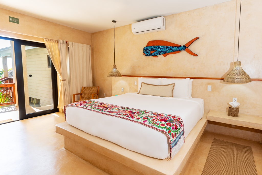 A hotel room with a large bed and a fish on the wall.