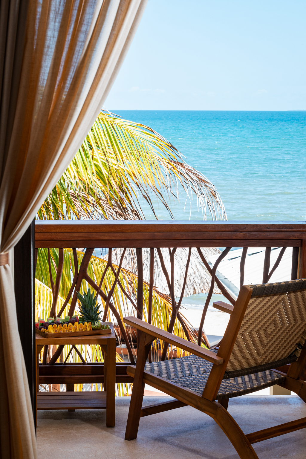 A chair is sitting on a balcony overlooking the ocean.