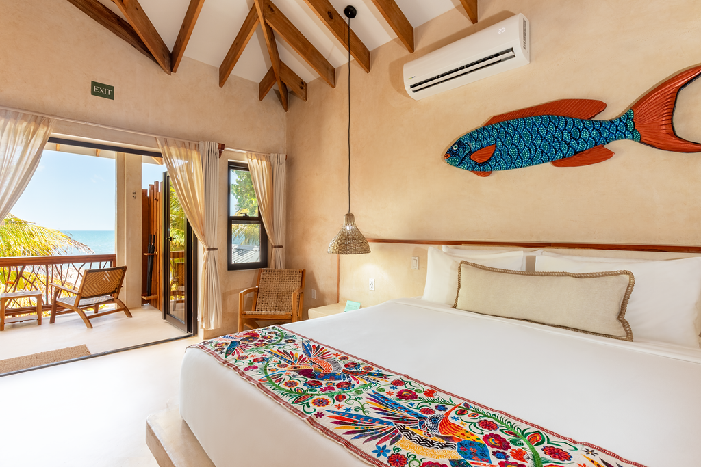 A hotel room with a large bed and a fish on the wall.