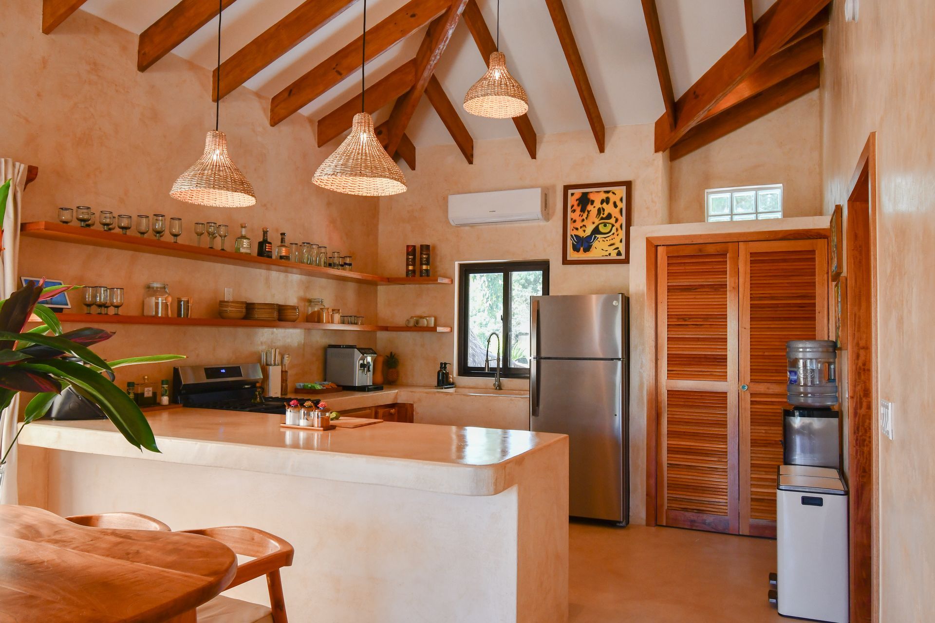 A kitchen with a stainless steel refrigerator and a wooden table and chairs.