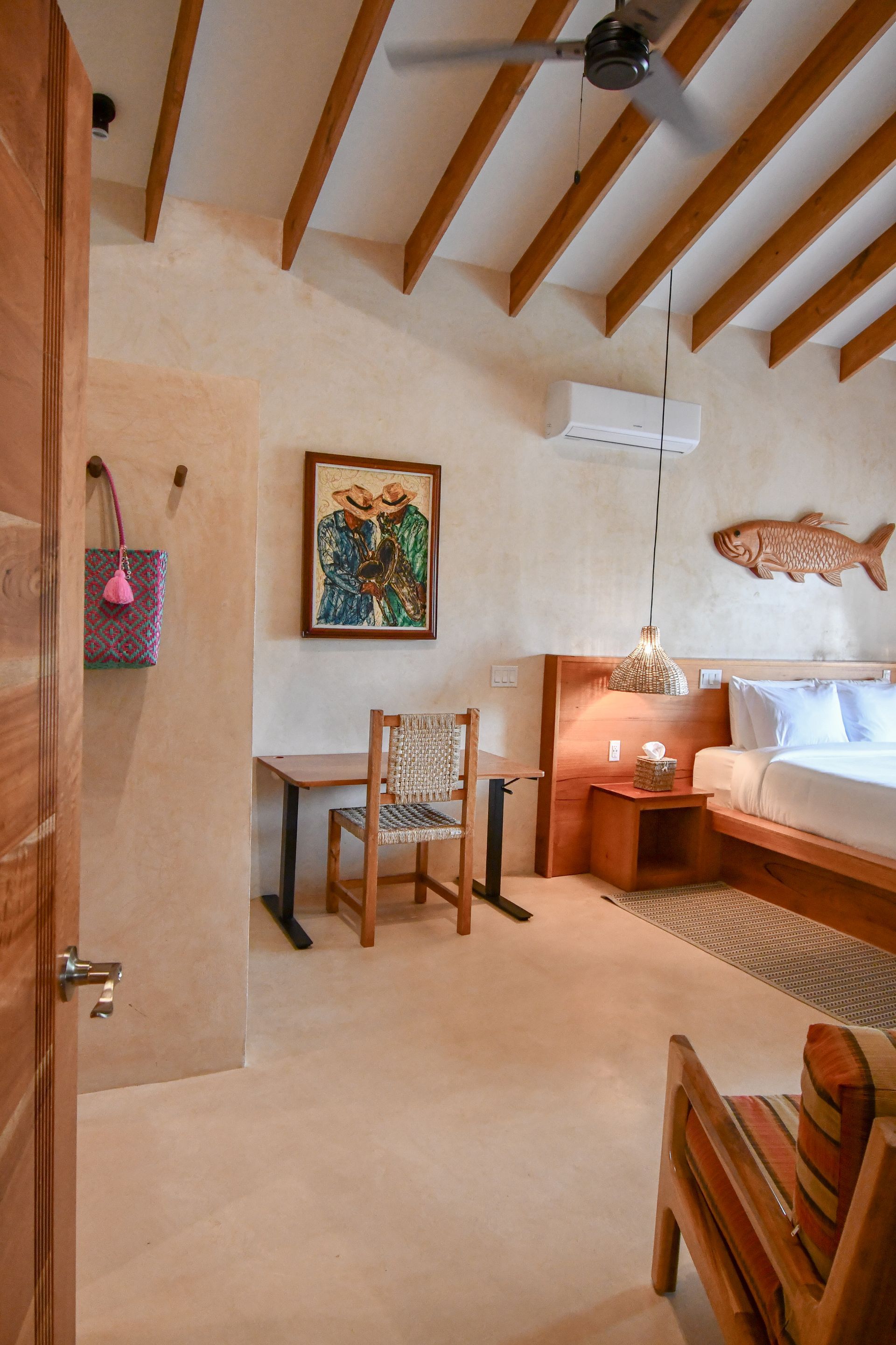 A bedroom with a bed , chair , desk and ceiling fan.