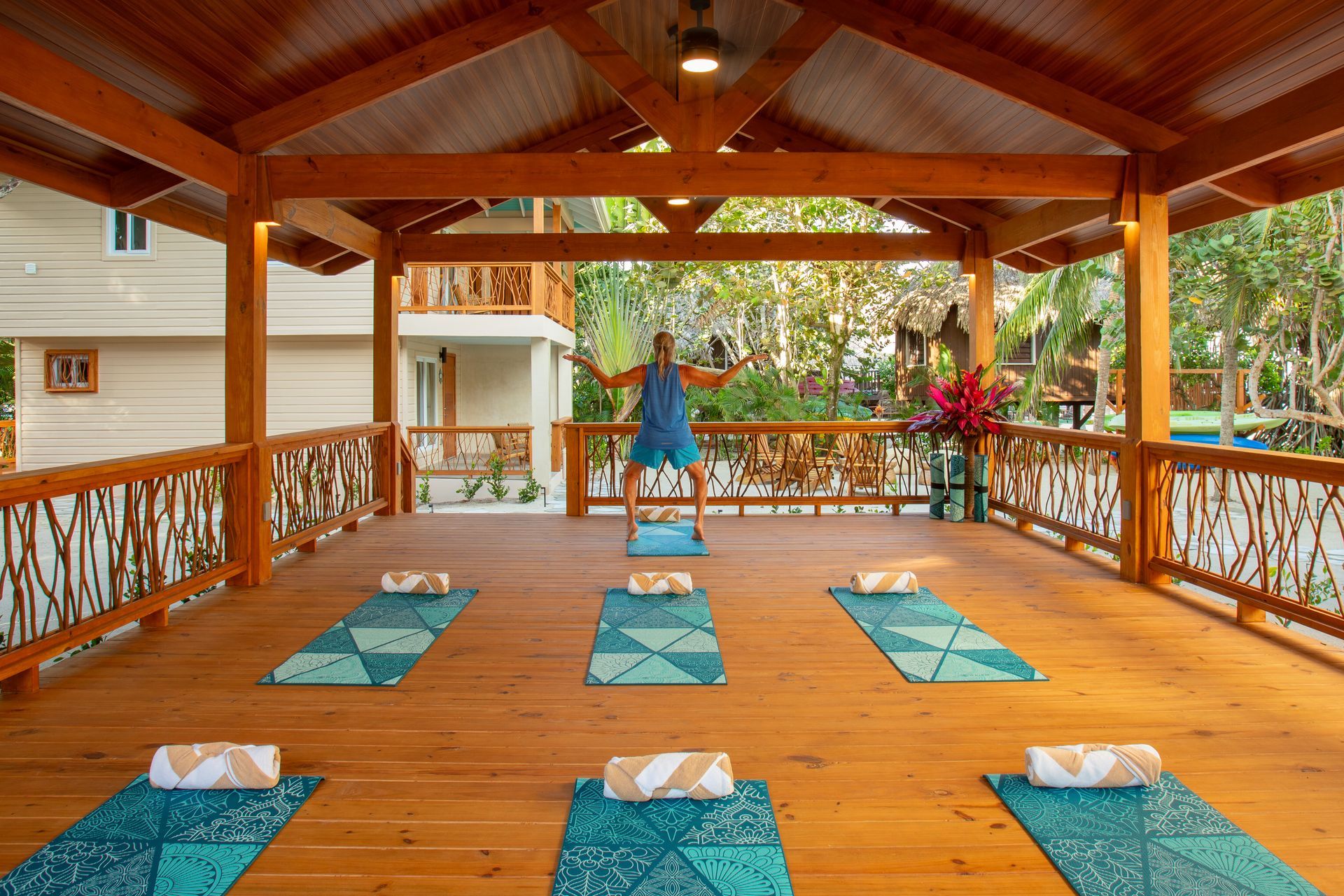 Breakfast picnic on striped blue cloth: avocado toast, fruit, pastries, eggs, beans, coffee, and drinks.