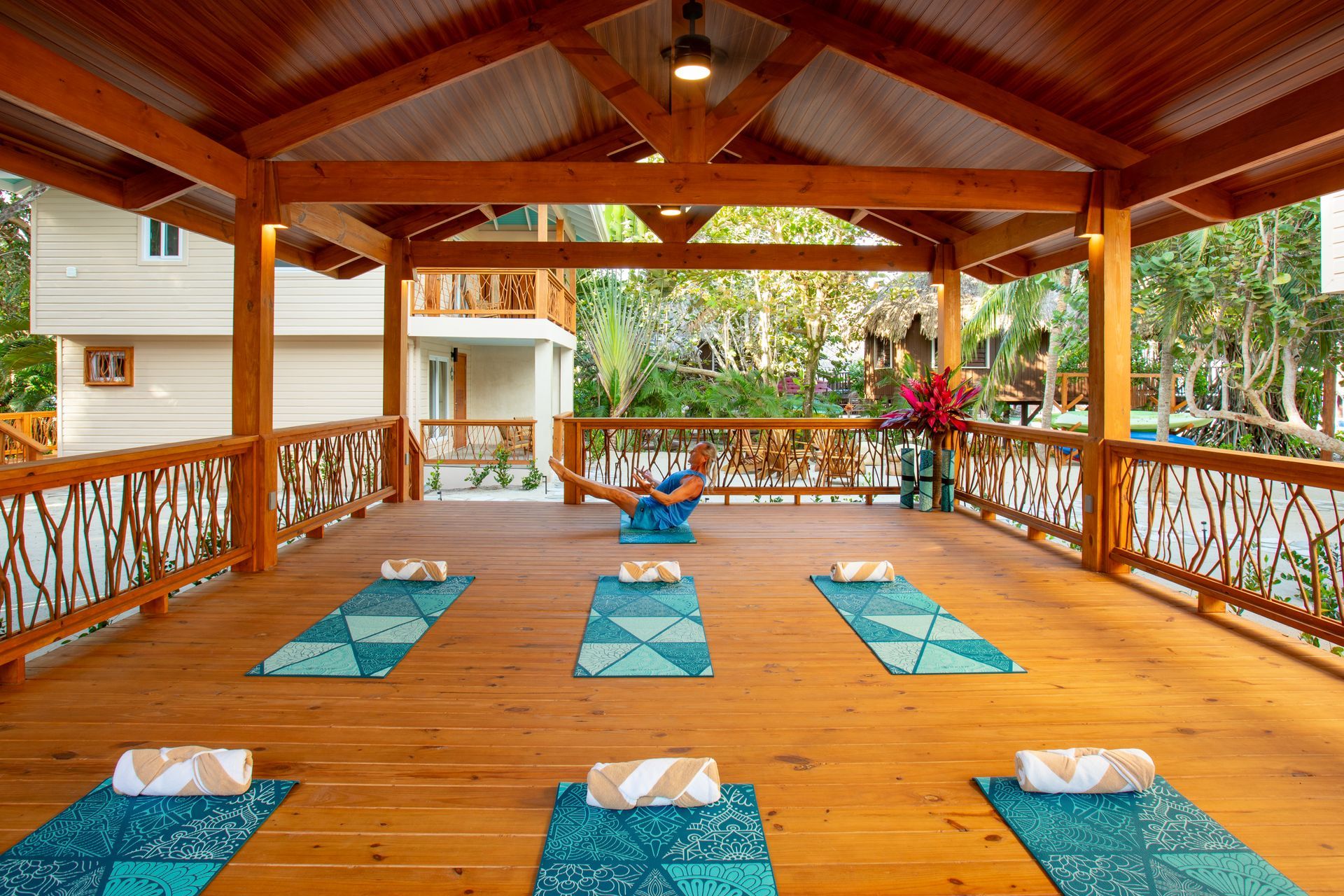 Strawberry frozen cocktail on a wooden surface with a blue ocean background, yellow-green palm frond.
