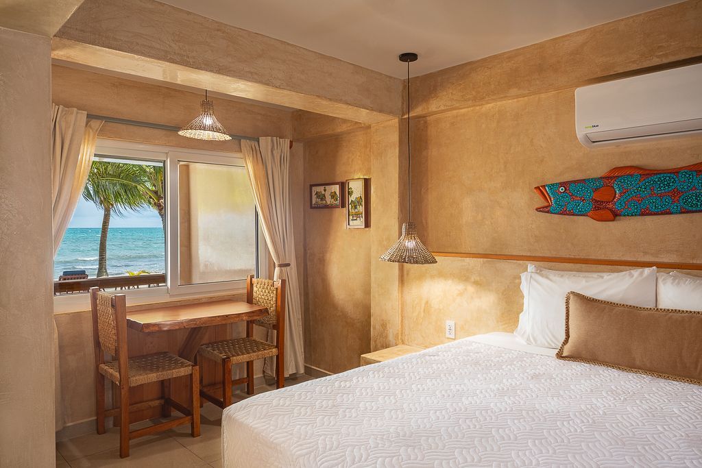 Kitchen with wooden beams, beige walls, and woven pendant lights. Includes stainless steel appliances and water dispenser.
