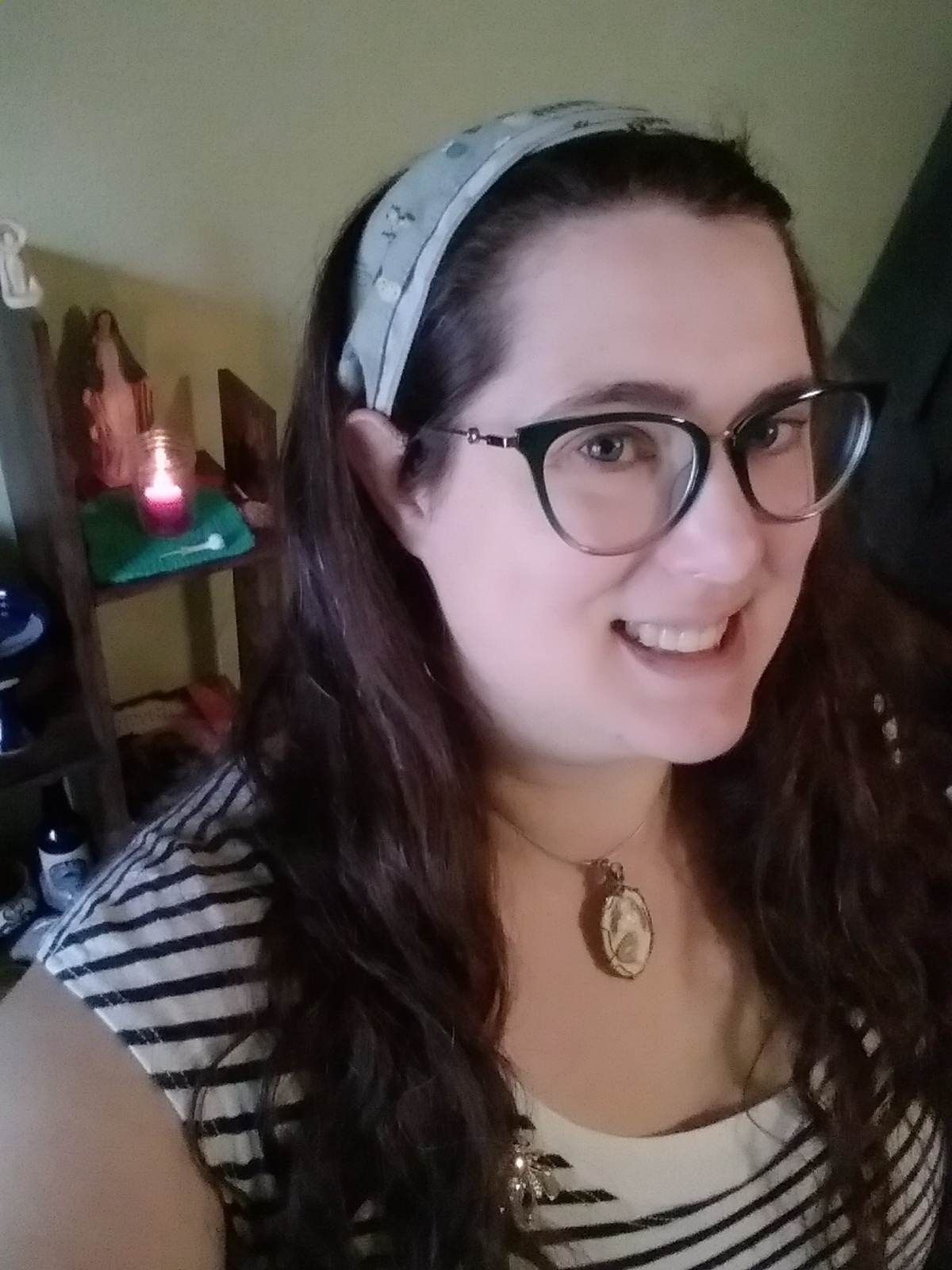 A woman wearing glasses and a headband smiles for the camera, Esme Dutcher.