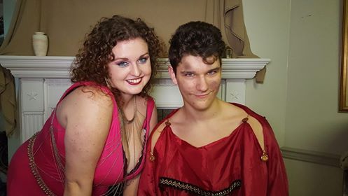 A man and a woman are posing for a picture in front of a fireplace, Brenna Grace and Alexander Malinski