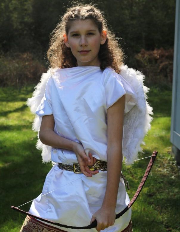 A woman in white with wings, holding a bow and arrow, representing Eros