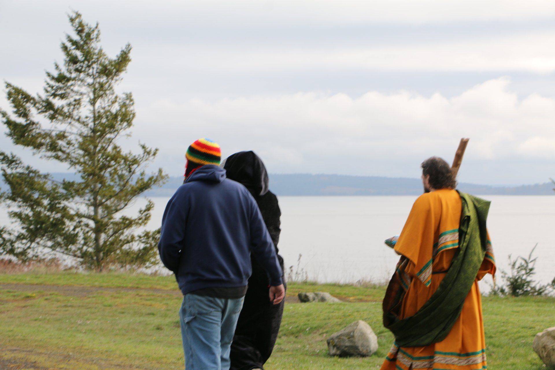 A group of people are walking by a body of water