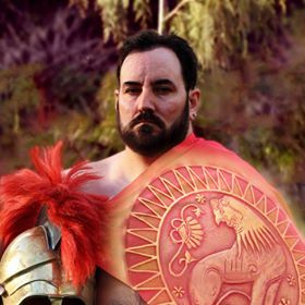 A man with a beard is wearing a helmet and shield, representing Ares.