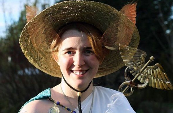 A woman wearing a straw hat with feathers on it, representing Hermes.
