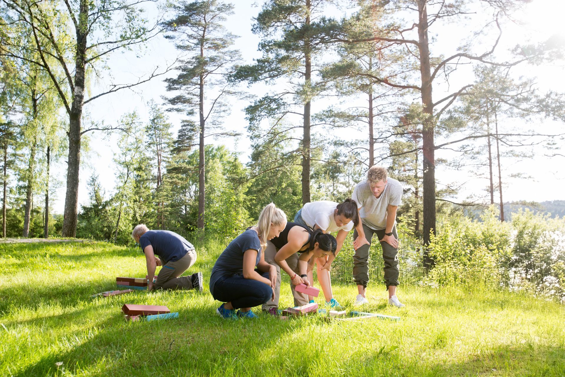 a group of people are kneeling on the grass in a park .