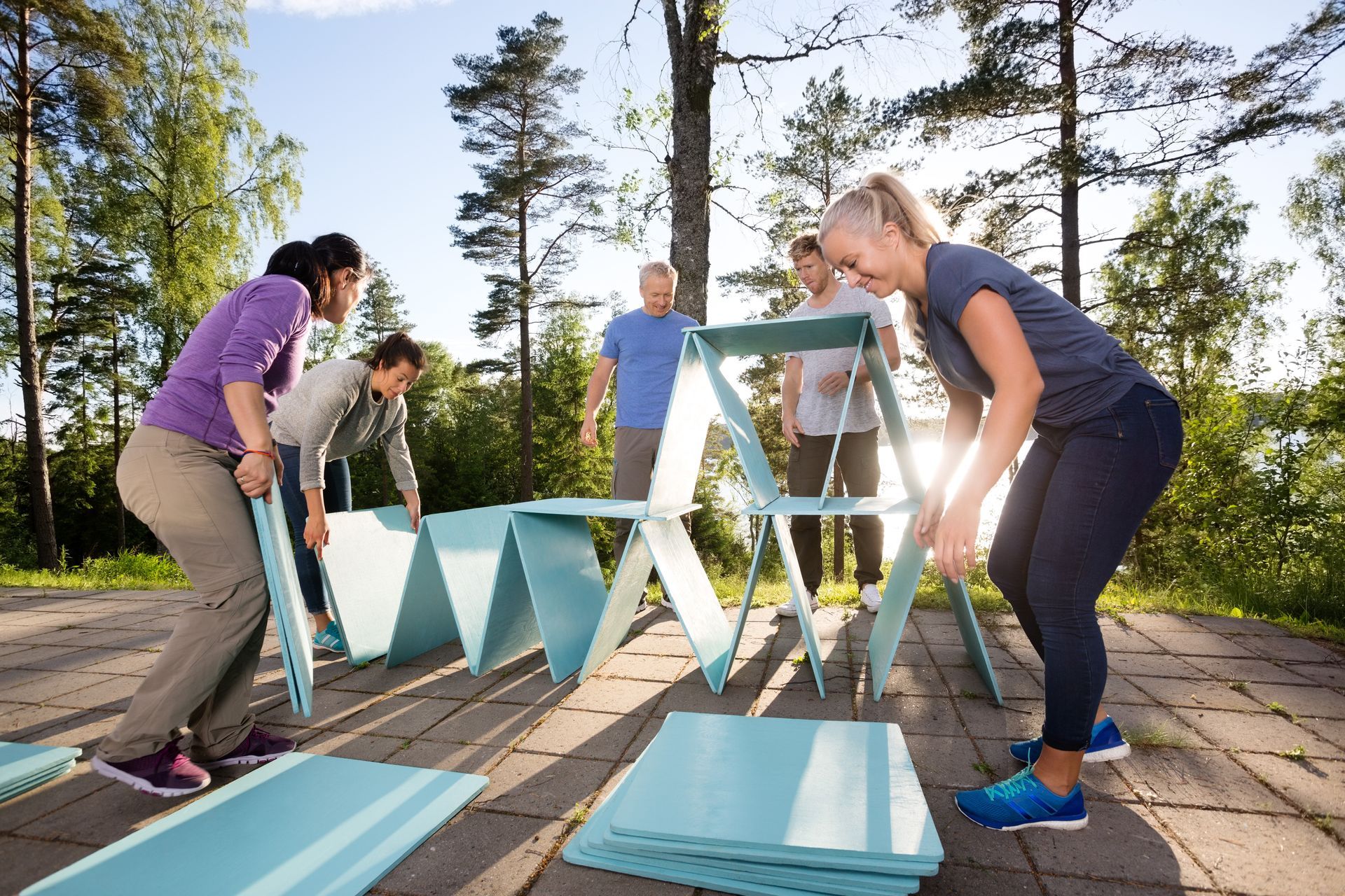a group of people are working together to build a picnic table .