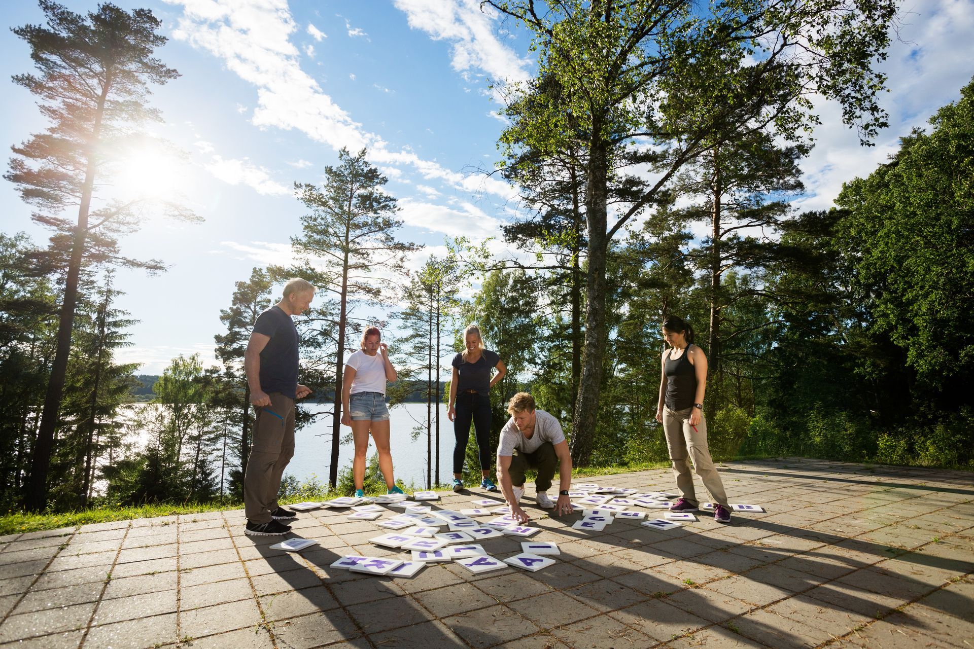 a group of people are playing a game on a patio near a lake .