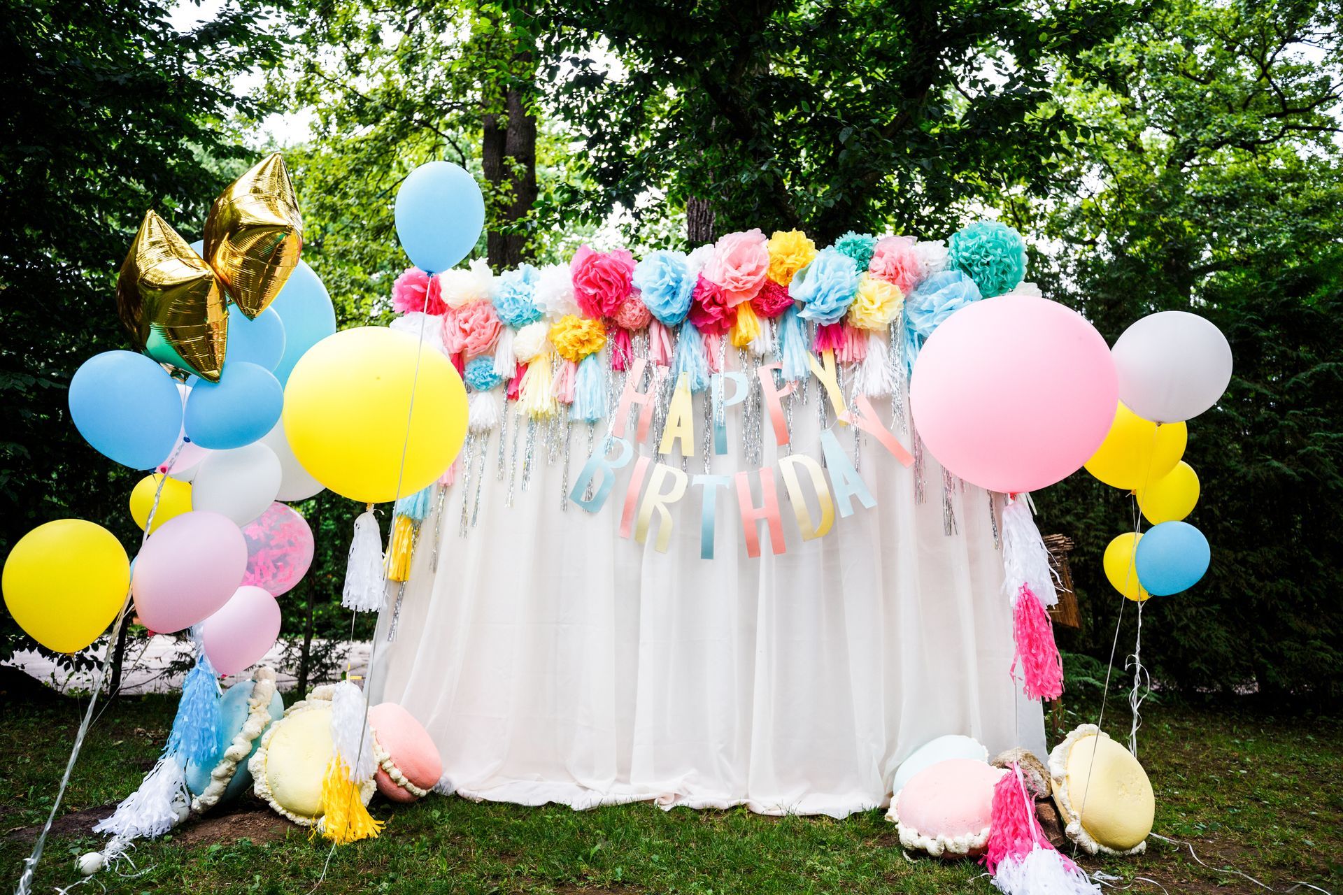 a table is decorated with balloons and flowers for a birthday party .