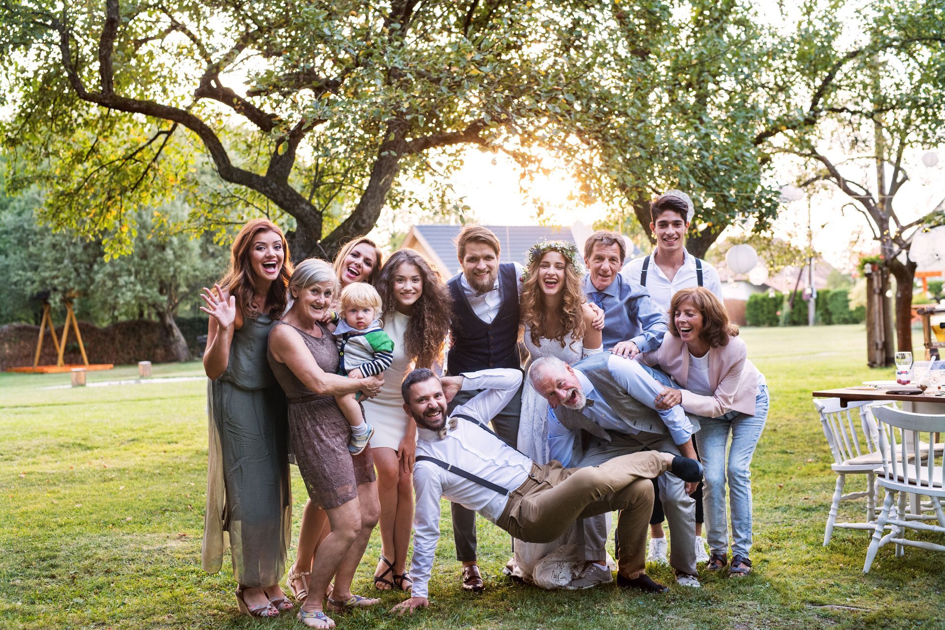 a large family is posing for a picture in a park .
