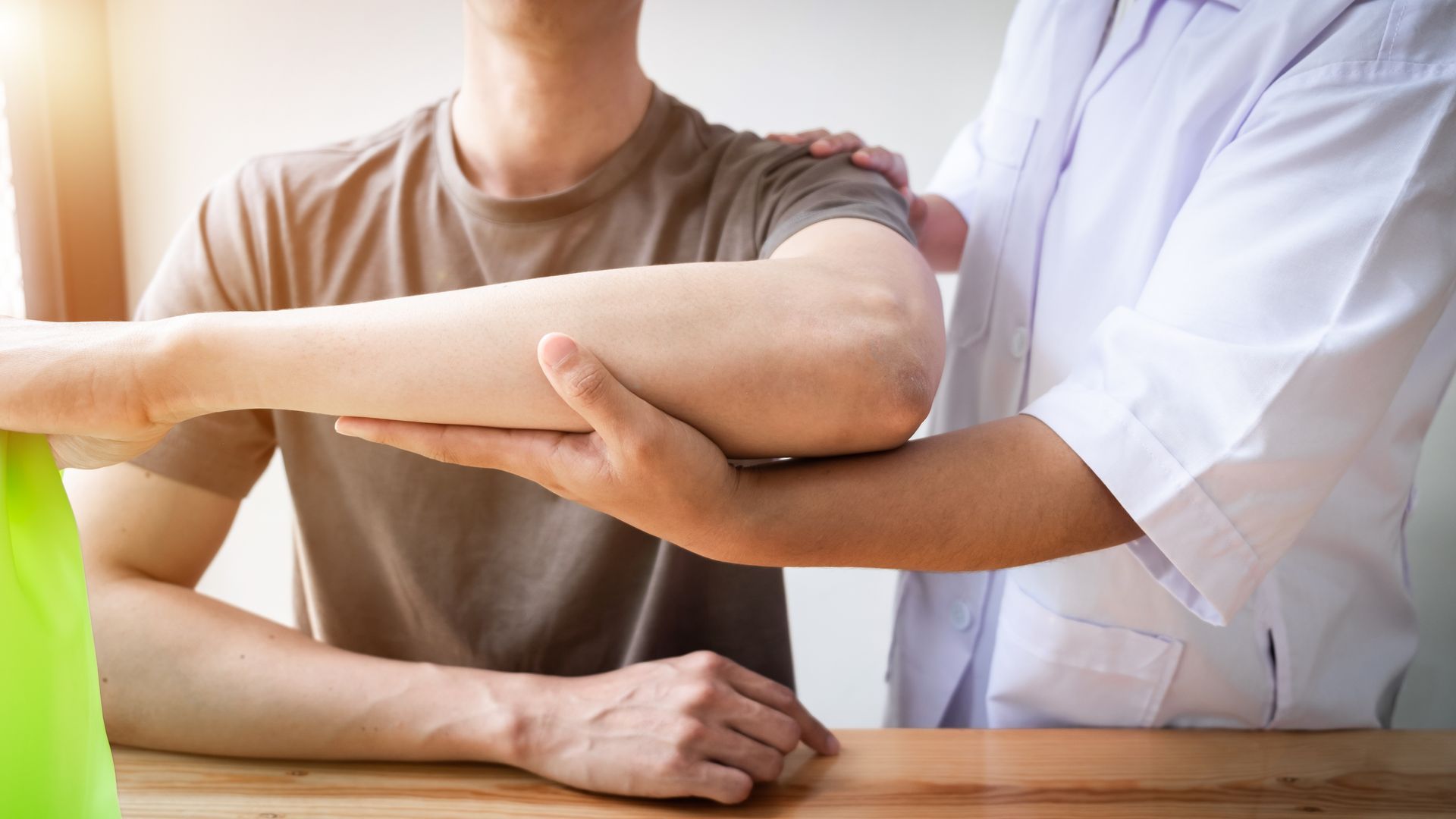 a man is getting his arm examined by a doctor .