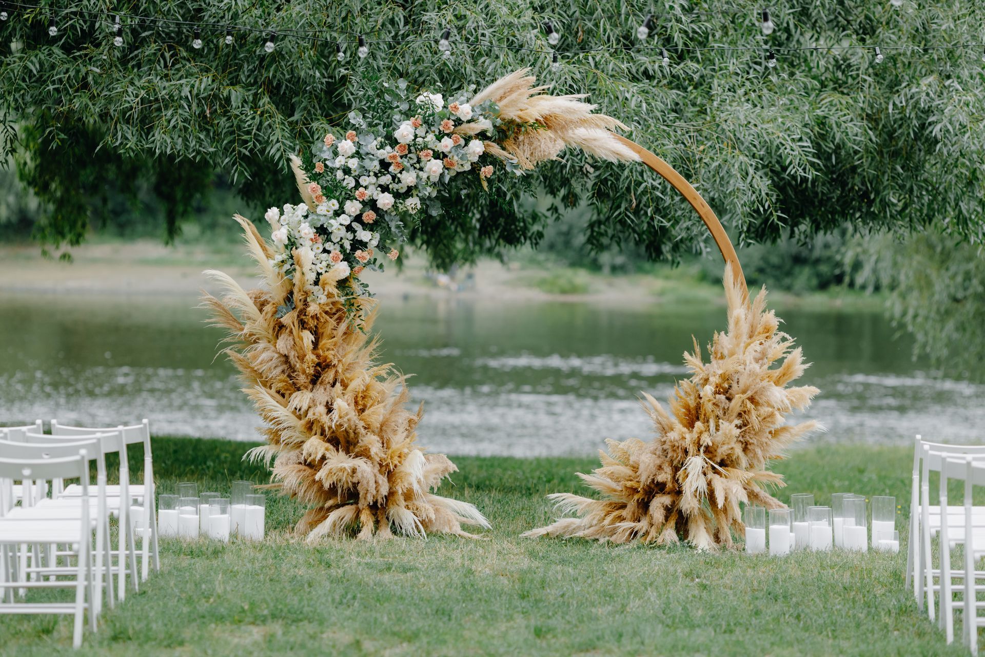 a wedding ceremony is taking place in front of a lake .