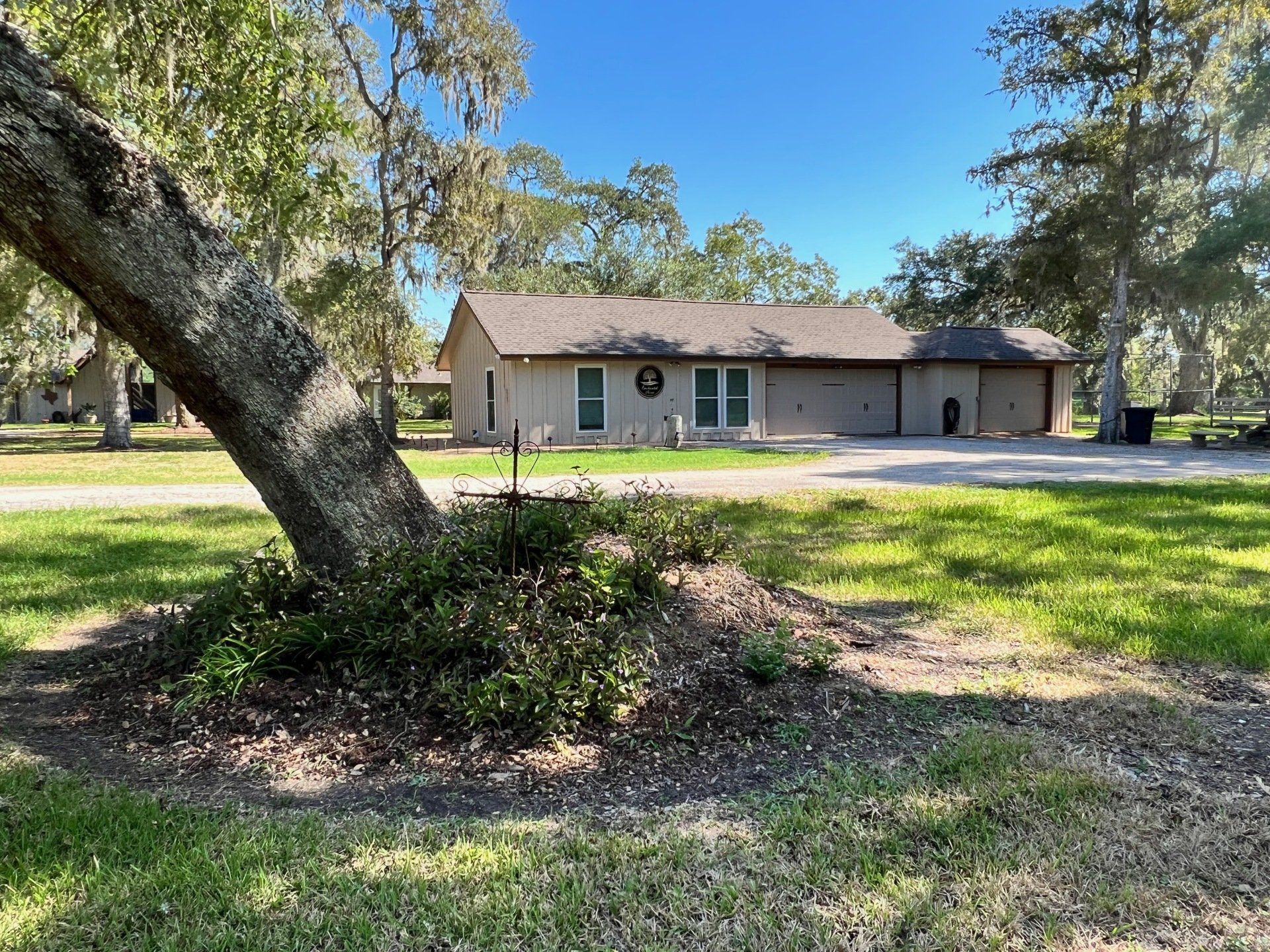 a house with a wreath on the front door is surrounded by trees and grass .