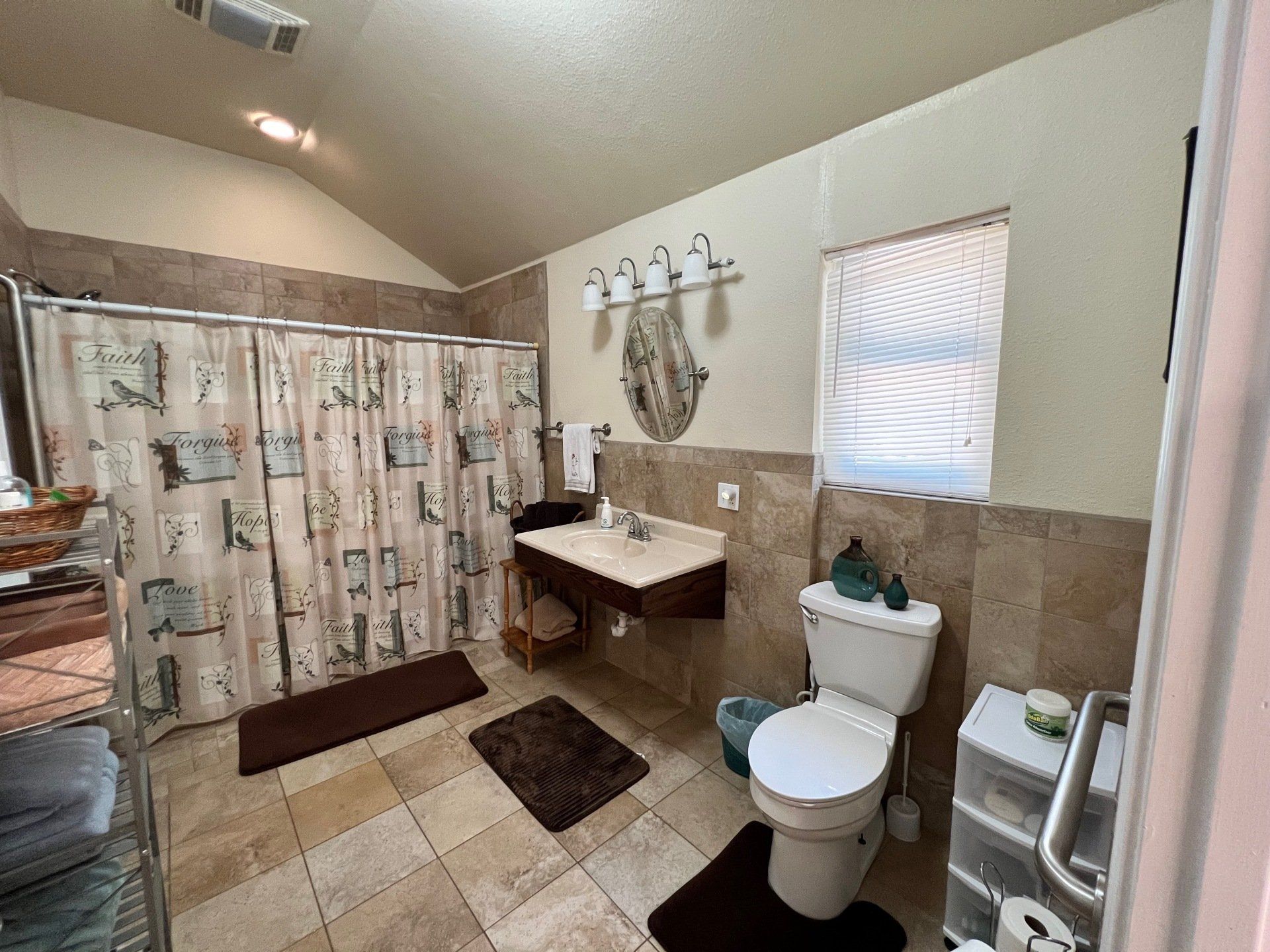 a bathroom with a toilet , sink and shower curtain .
