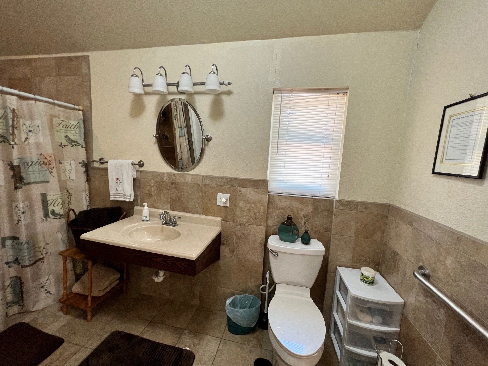 a bathroom with a toilet , sink , mirror and shower curtain .