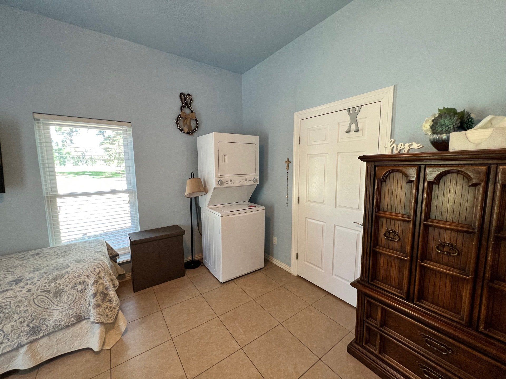 a bedroom with a washer and dryer and a dresser .