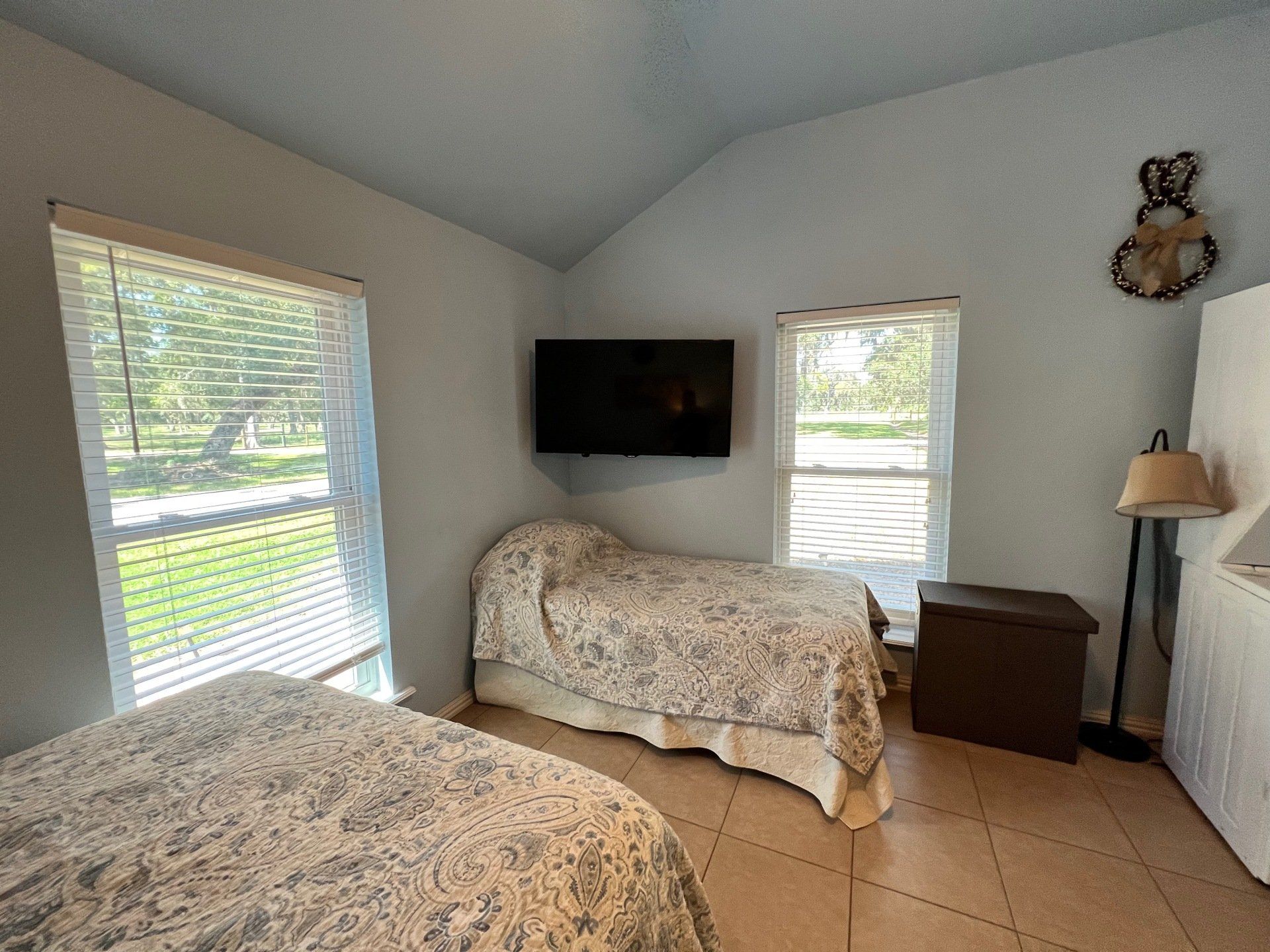 a bedroom with two beds and a flat screen tv on the wall .