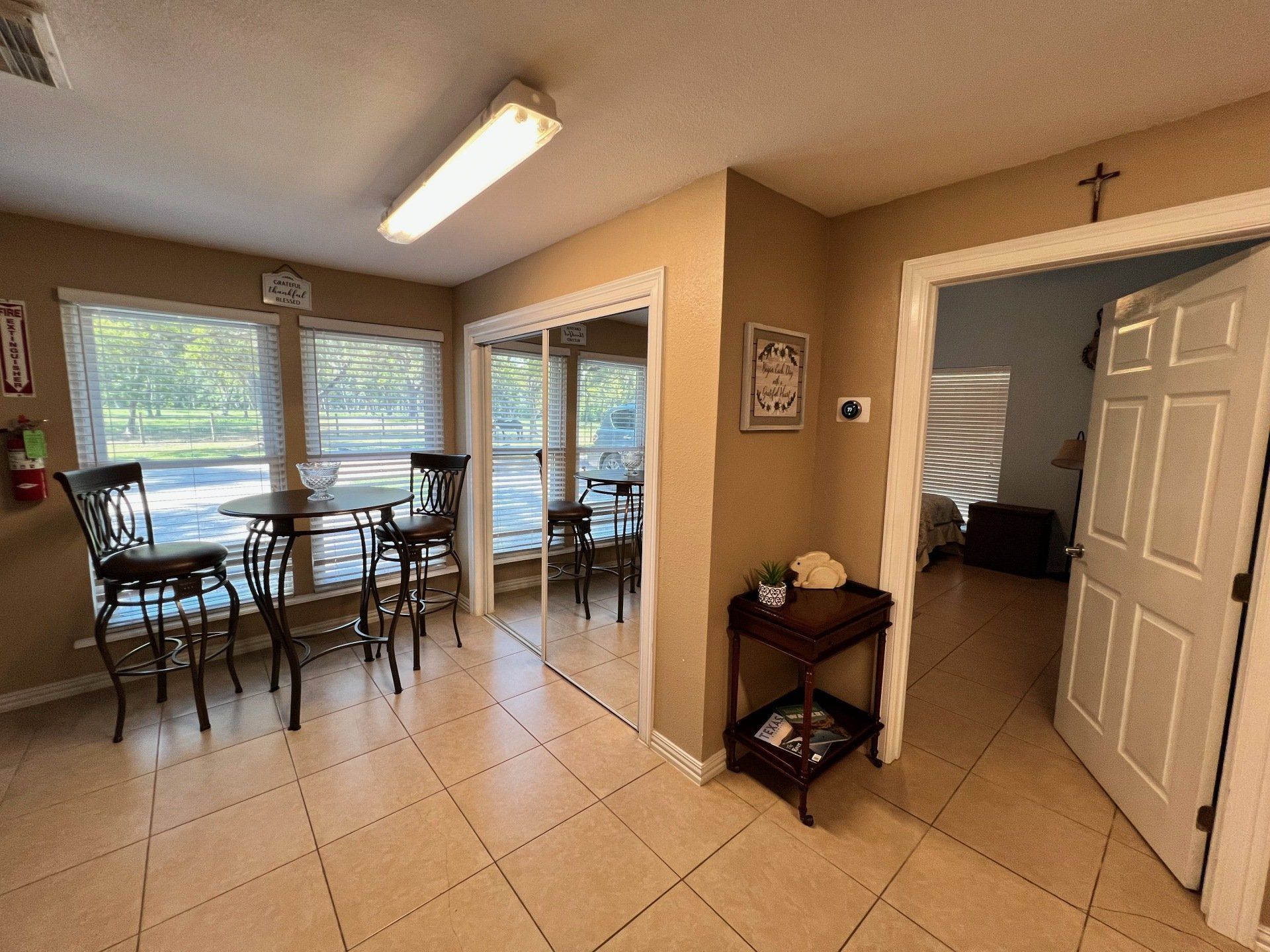 a room with tables and chairs and a cross on the wall