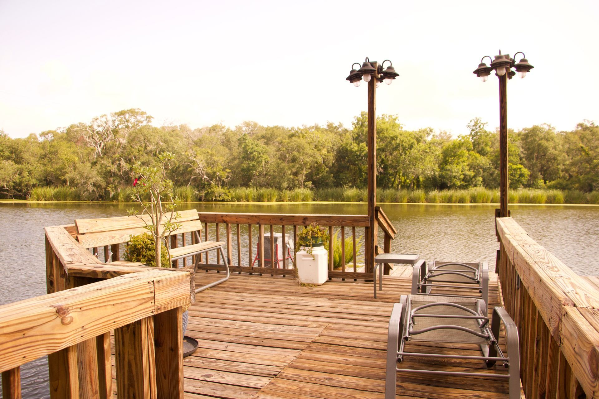 a wooden deck overlooking a lake with chairs on it