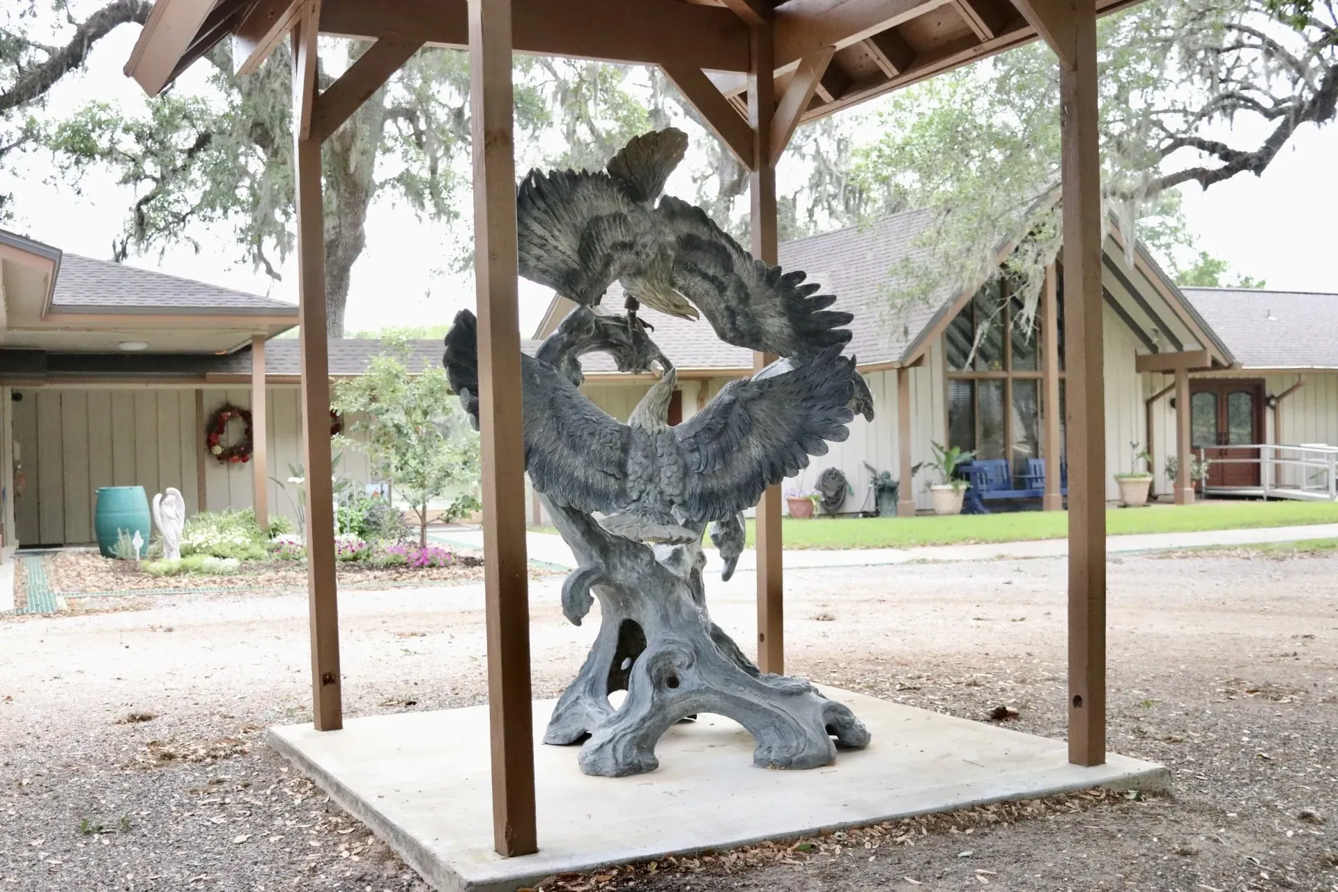a statue of two eagles is under a gazebo in front of a house