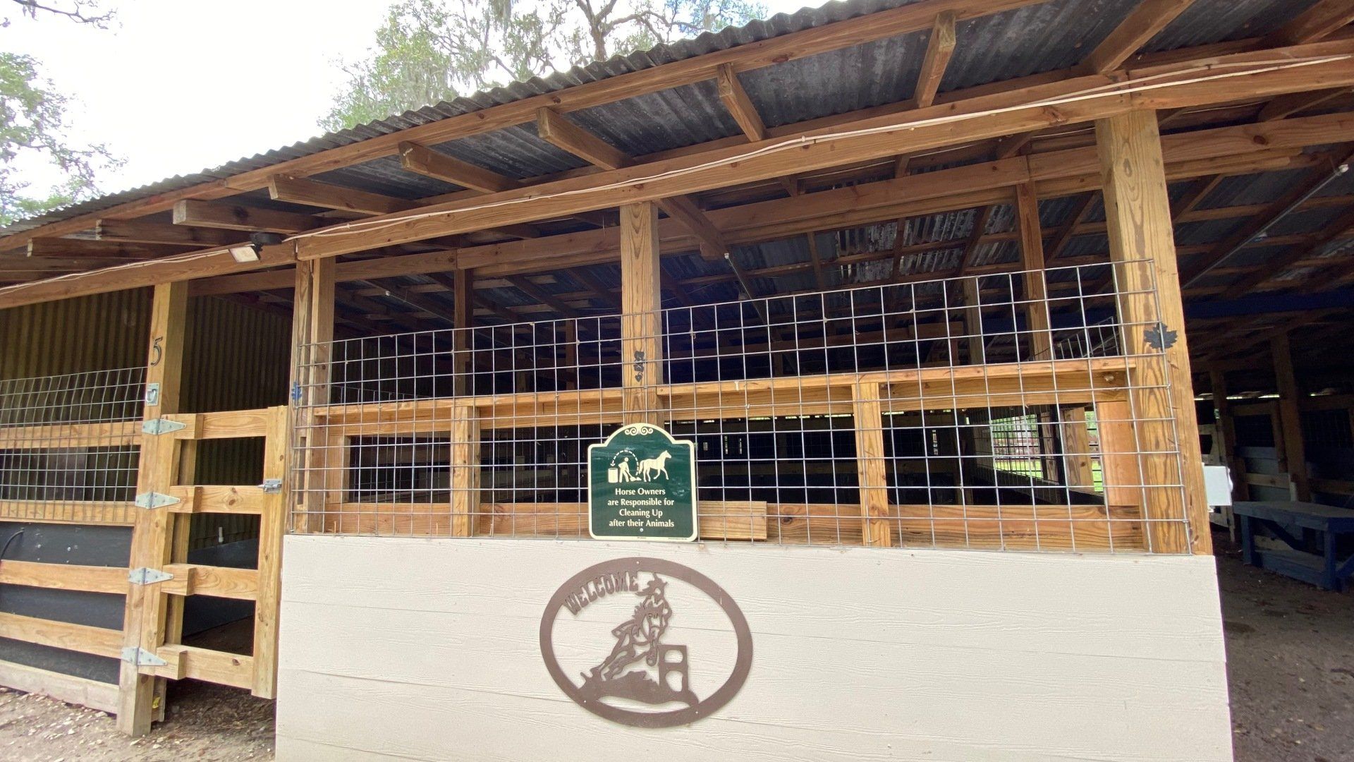 a wooden barn with a sign on the side of it .
