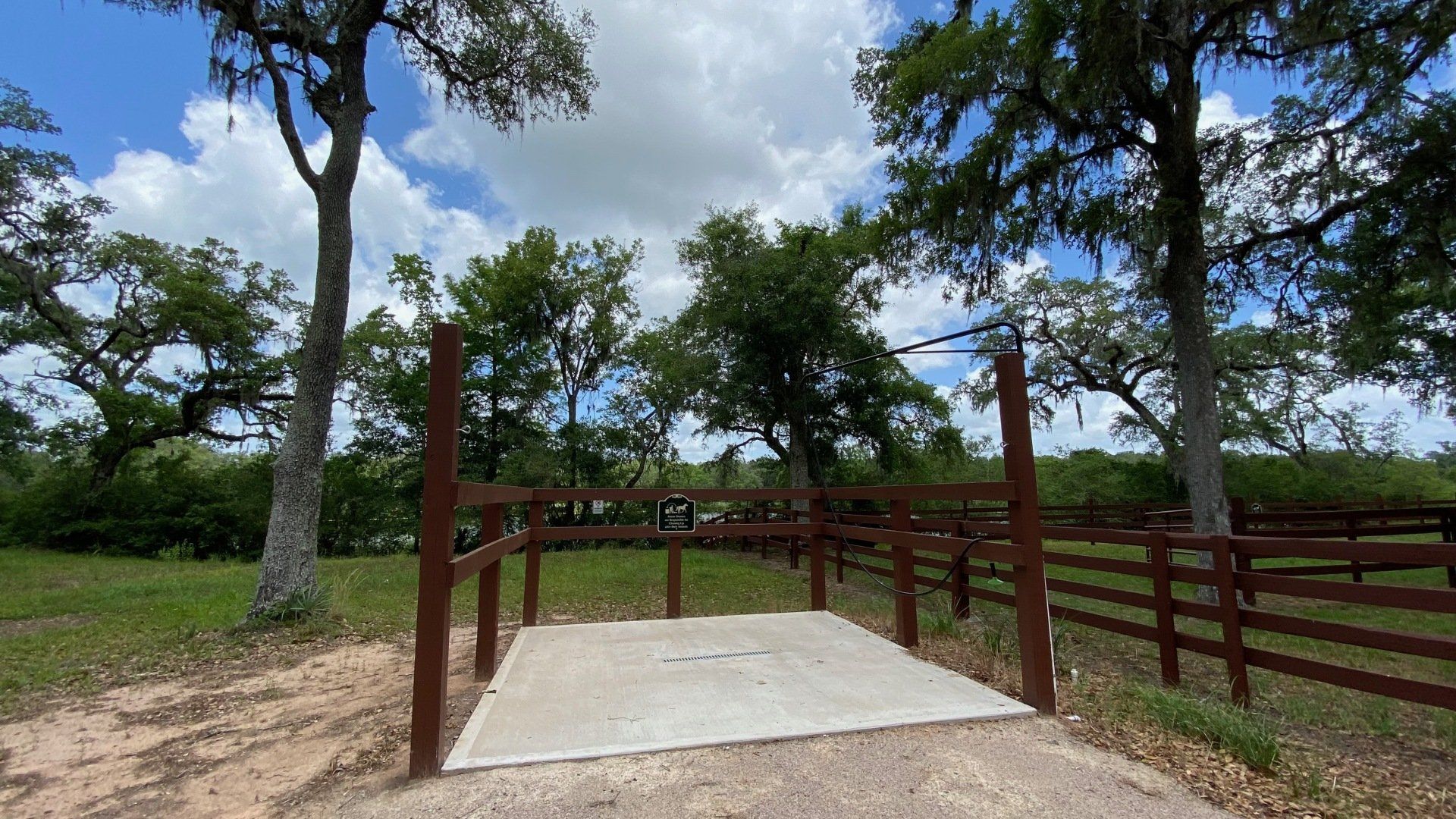 a wooden fence with a concrete platform in the middle of a field .